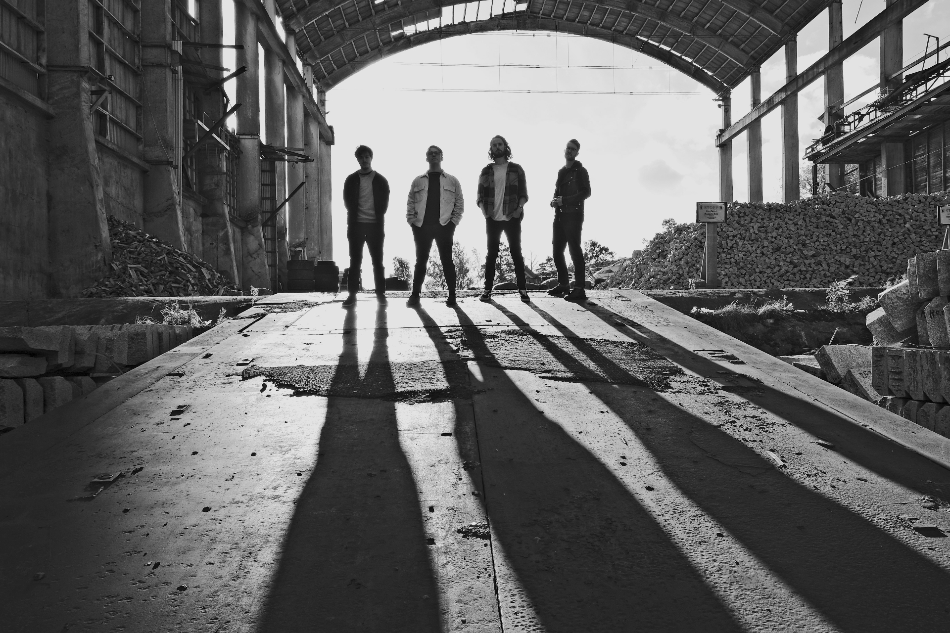 Solár — the four band members silhouetted in a derelict industrial hall
